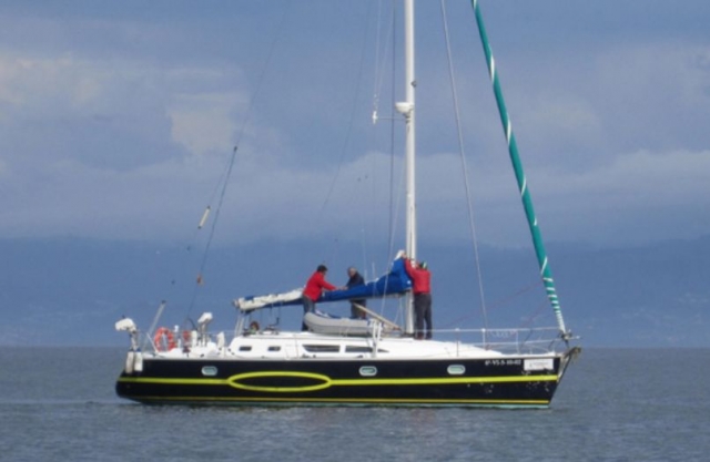 hombres colocando la vela a un velero